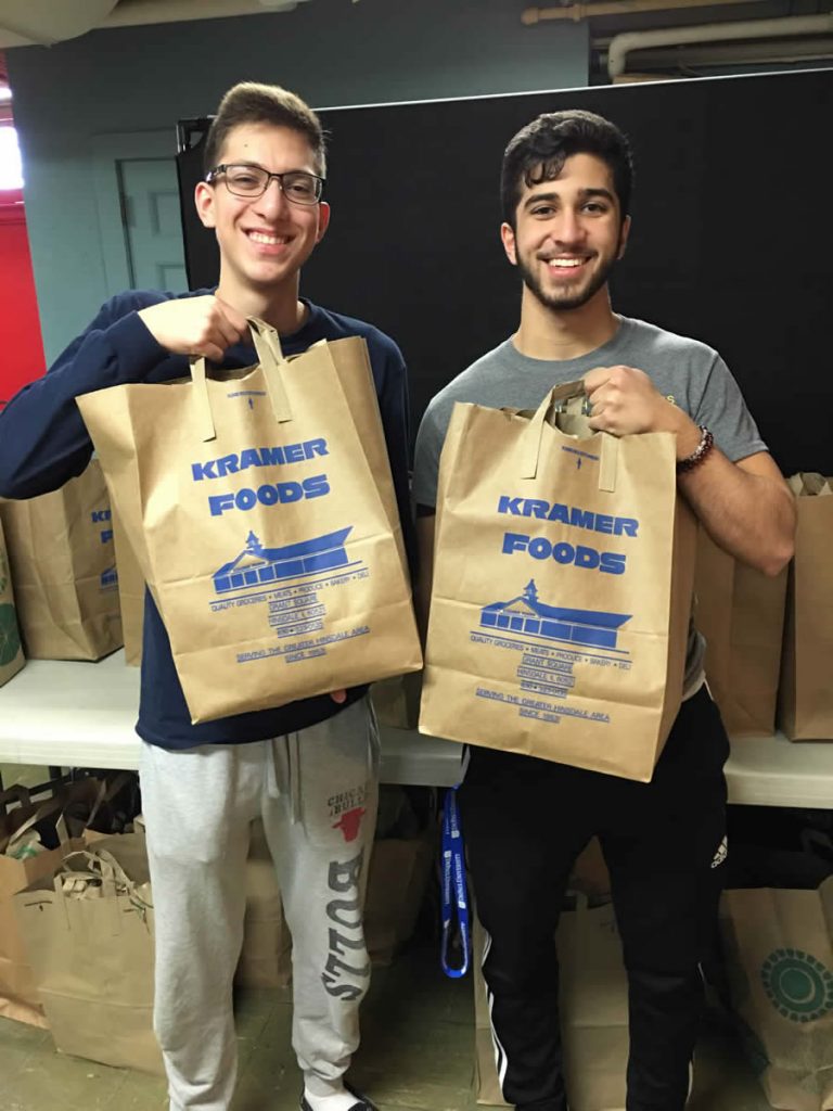 two boys carrying grocery bags