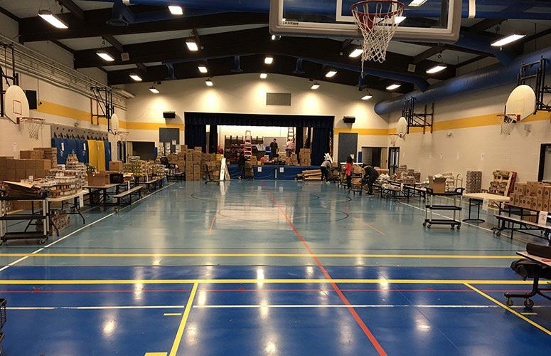 Overview of volunteer set-up for food bag packing at Ann M Jeans Elementary School